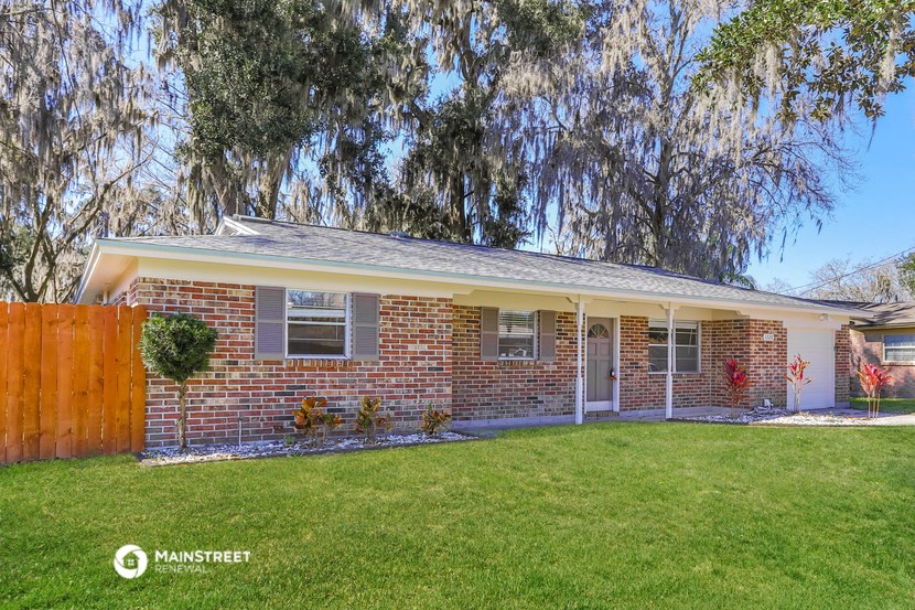 a brick house with a lawn and a tree