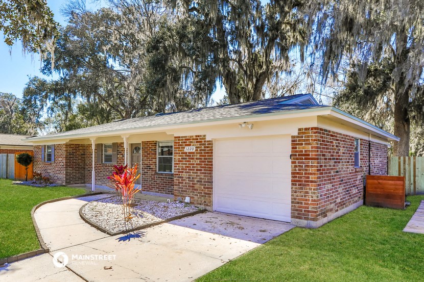 a small brick house with a white garage door
