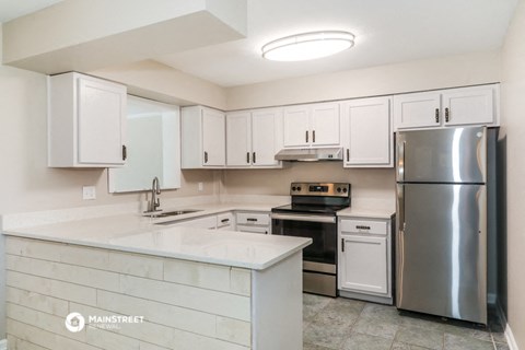a white kitchen with stainless steel appliances and white cabinets