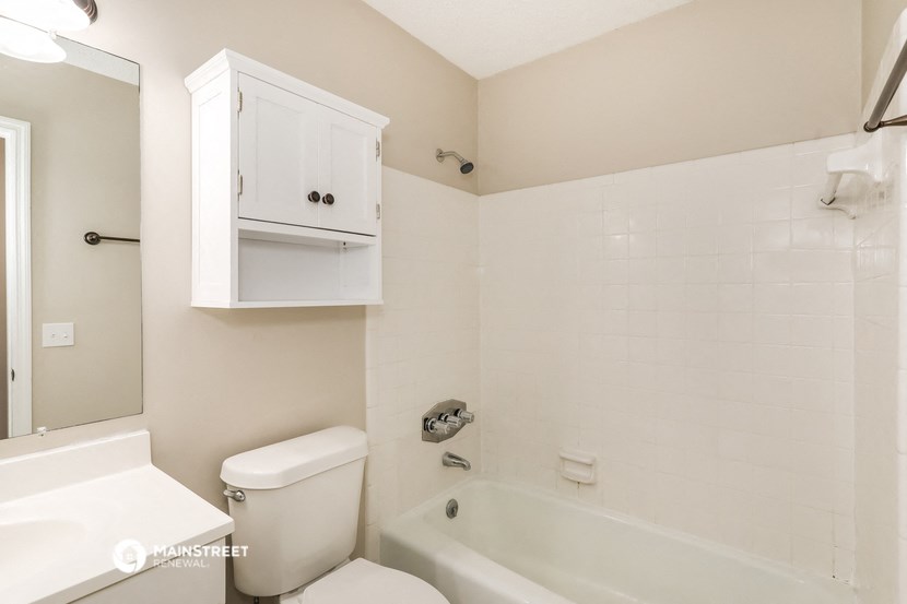 a white bathroom with a tub and toilet and a sink