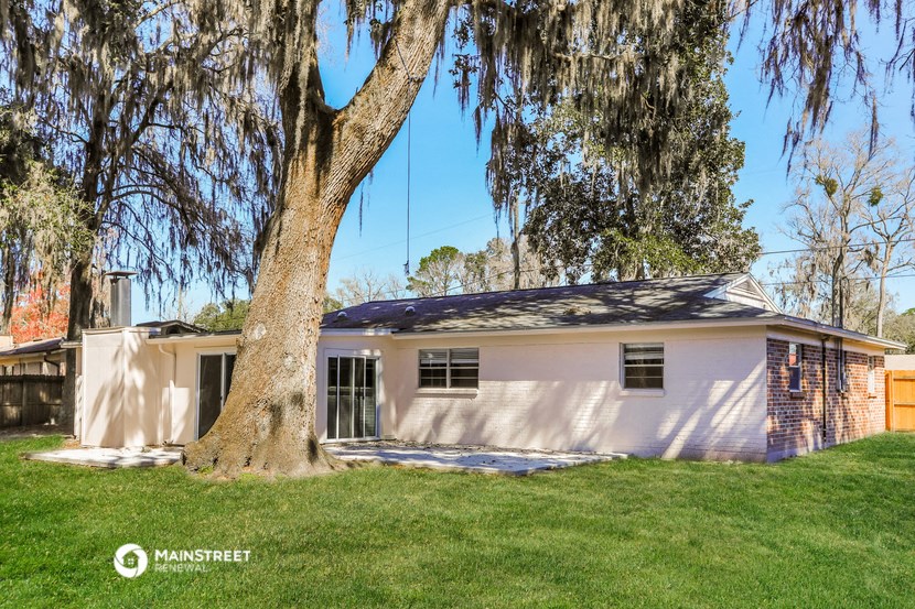 a white house with a tree in front of it