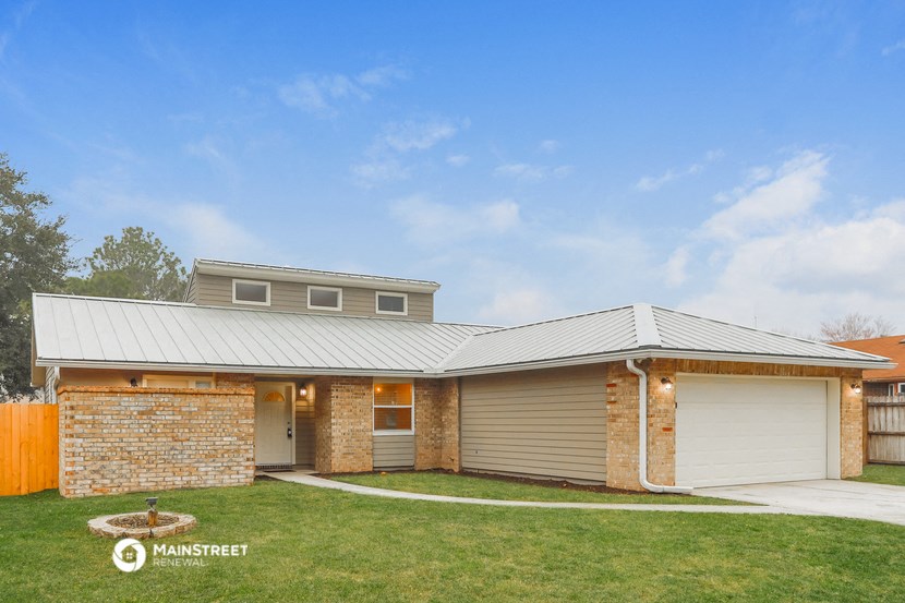 the exterior of a brick house with a metal roof