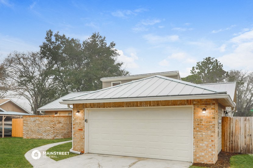 the front of a brick garage with a white garage door