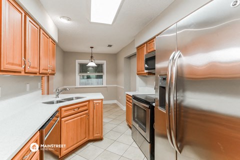 a kitchen with wooden cabinets and stainless steel appliances
