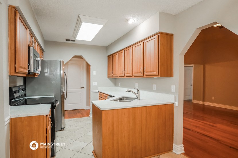 a kitchen with wooden cabinets and a sink and a refrigerator