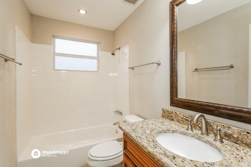 a bathroom with a shower toilet and sink and a mirror