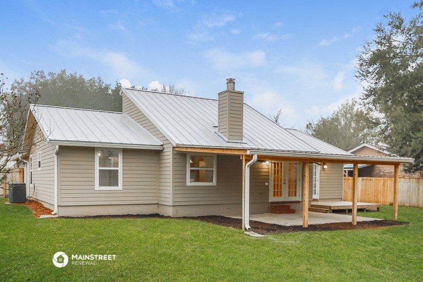 a small house with a metal roof and a porch