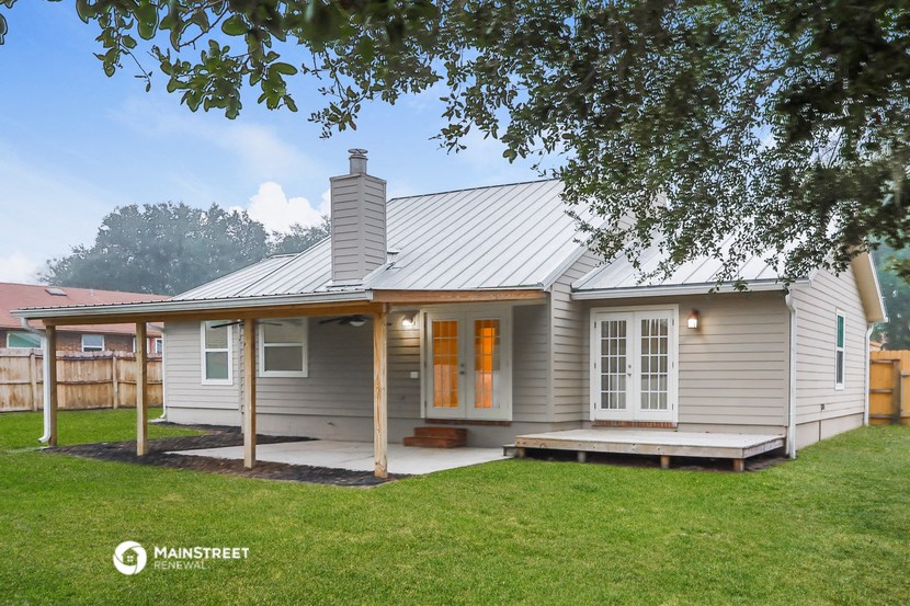 a white house with a metal roof and a porch