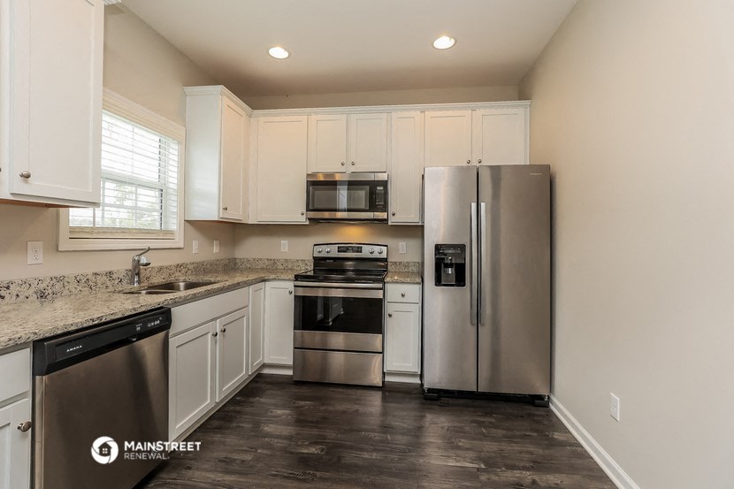 a kitchen with white cabinets and stainless steel appliances