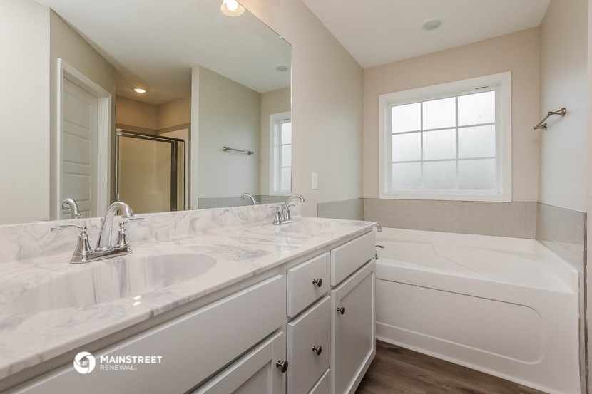 a bathroom with a sink and a tub and a mirror