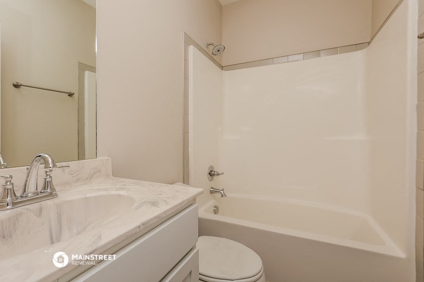 a bathroom with a tub and a sink and a toilet