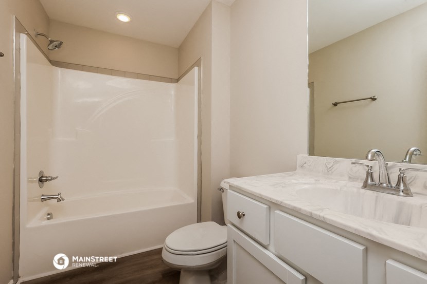 a bathroom with a shower and a sink and a toilet