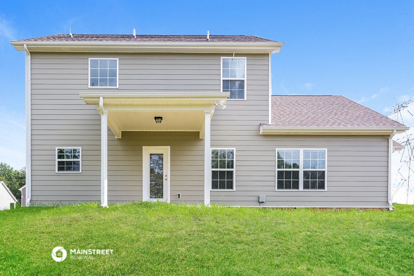 a gray house with a lawn in front of it