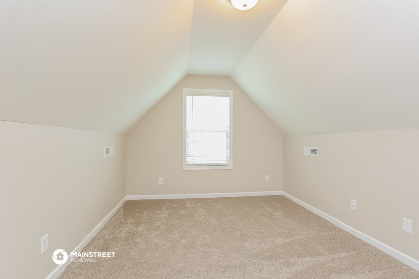 the upstairs bedroom with carpet and a window
