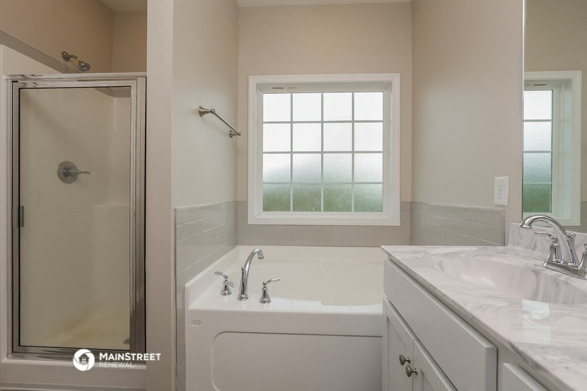 a bathroom with a tub and a shower and a sink