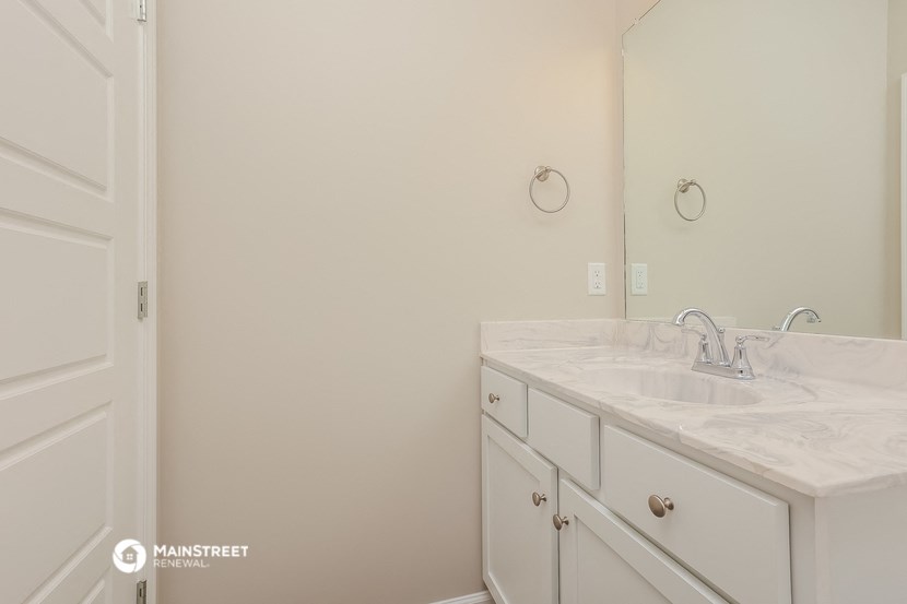 a bathroom with white cabinets and a sink and a mirror