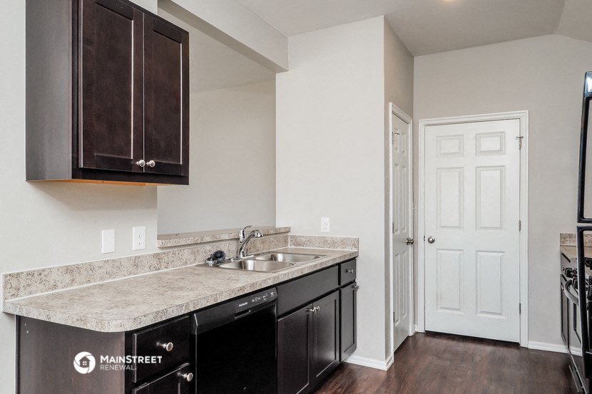a kitchen with a sink and a refrigerator and a door