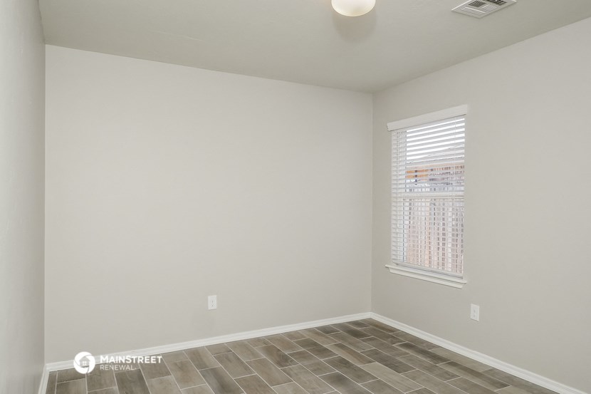 the spacious living room with a large window and tiled flooring