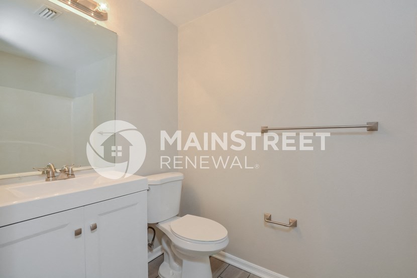 a bathroom with a toilet and a sink and a mirror