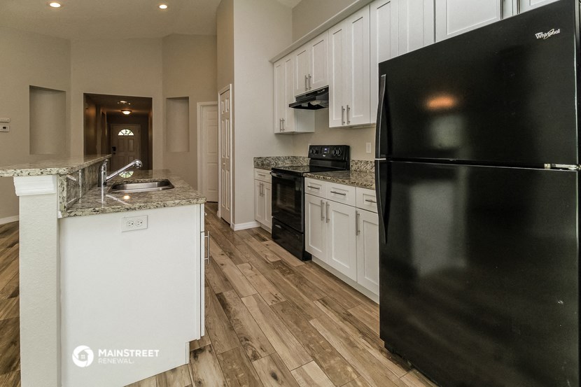 a kitchen with black appliances and white cabinets
