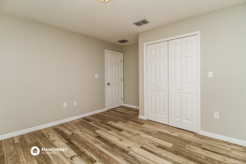 the spacious living room with two closets and wood flooring