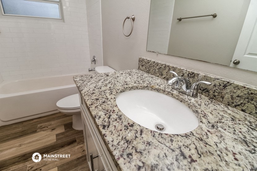 a bathroom with a marble counter top and a sink and a toilet