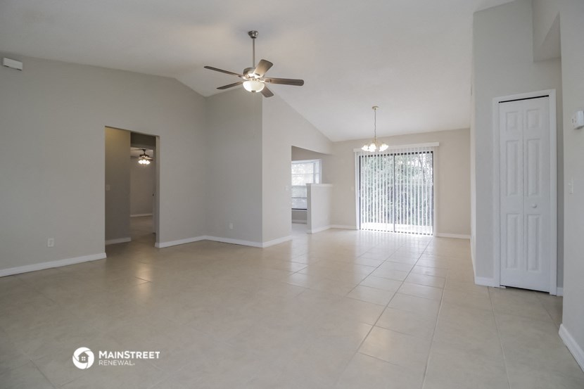 an empty living room with a ceiling fan
