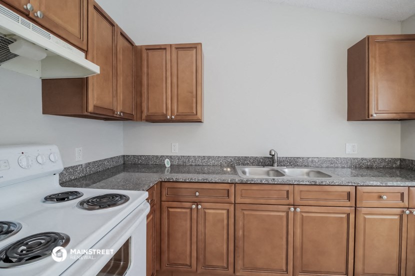 a kitchen with wooden cabinets and a stove and a sink