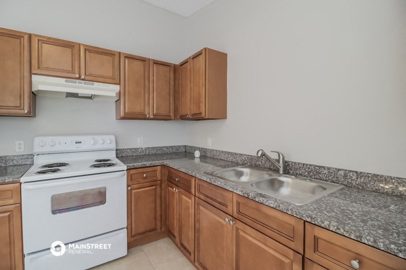 a kitchen with granite counter tops and wooden cabinets