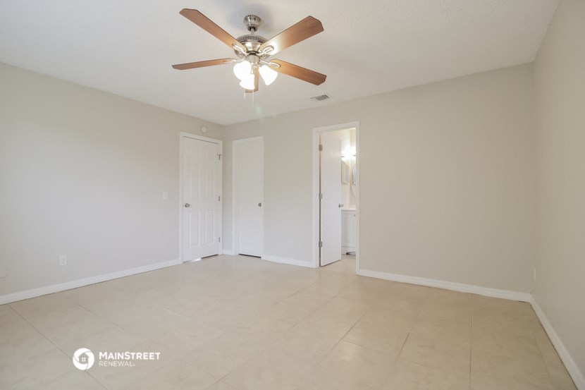 an empty living room with a ceiling fan