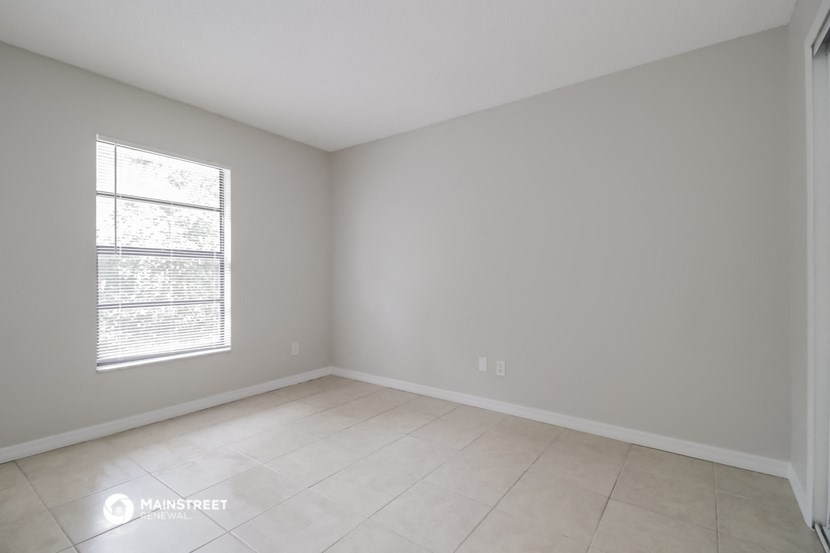 an empty room with a window and a tiled floor