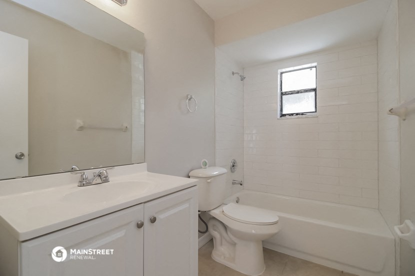 a white bathroom with a toilet and a sink