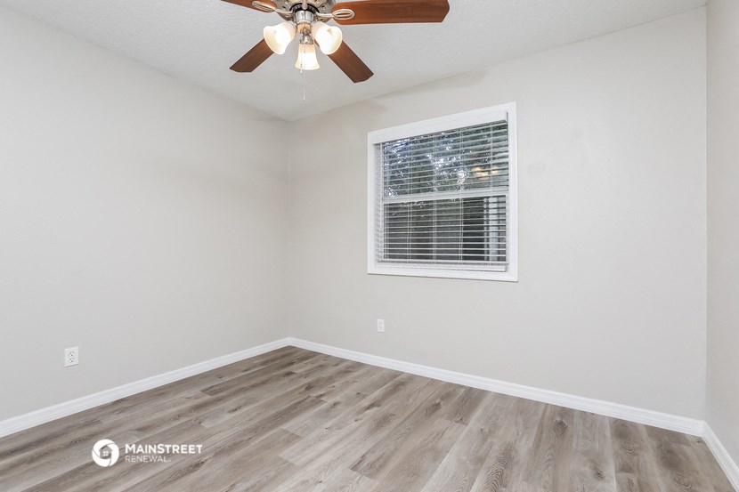 the living room of our studio apartment atrium with wood floors and a ceiling fan