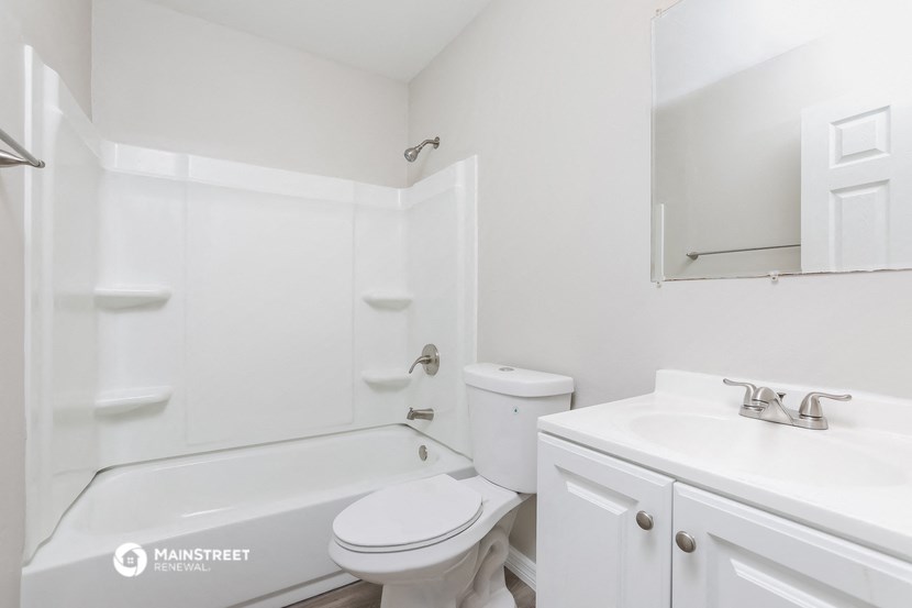 a white bathroom with a sink toilet and bath tub