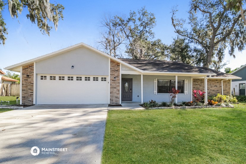 a white house with a lawn and a white garage door