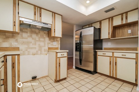 a kitchen with white cabinets and a stainless steel refrigerator