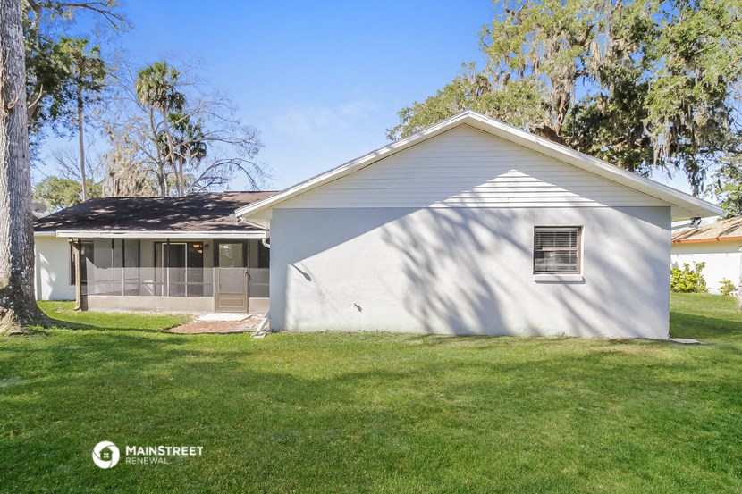 a white house with a yard and a tree