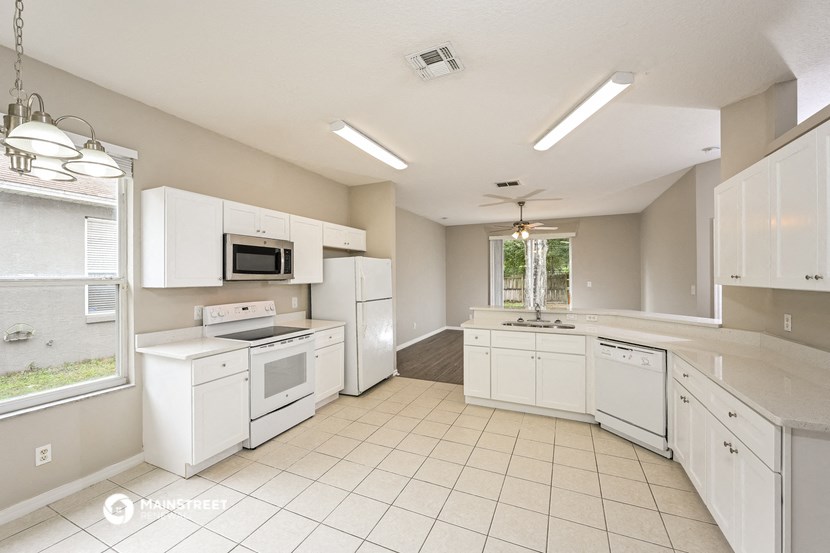 a large kitchen with white appliances and white cabinets