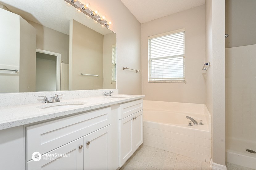 a bathroom with a sink and a tub and a mirror