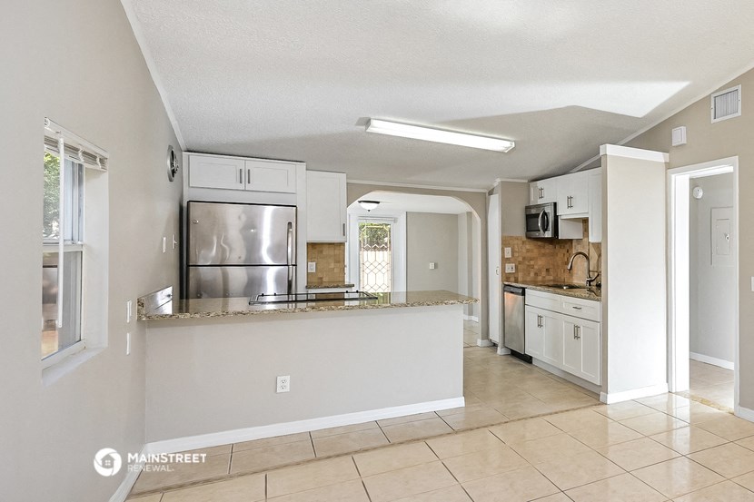 a kitchen with a counter top and a stainless steel refrigerator