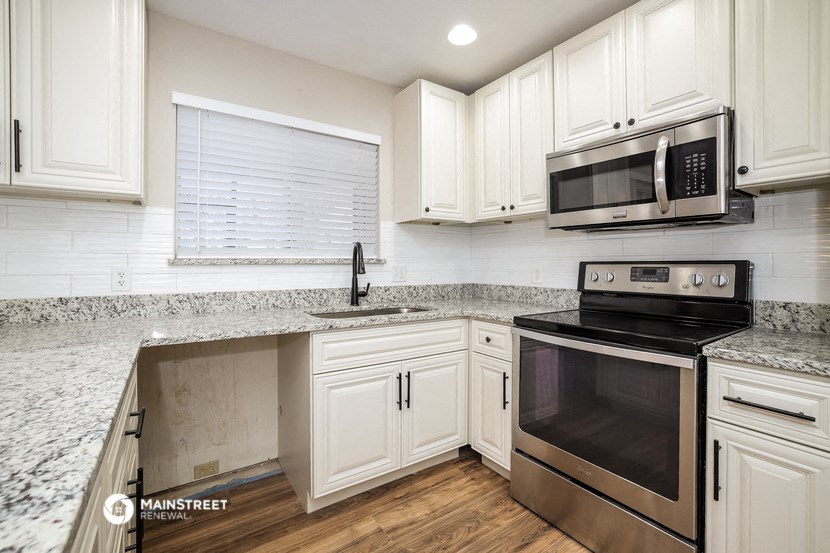 a kitchen with white cabinets and stainless steel appliances