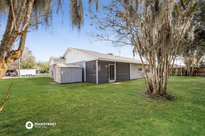 a gray house with a yard and a tree