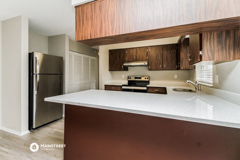 a kitchen with a white counter top and a refrigerator
