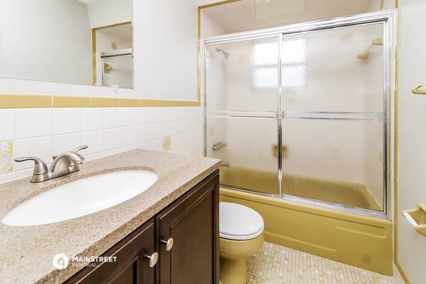 a bathroom with a shower and a sink and a toilet