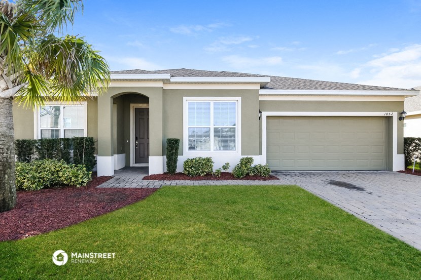 the exterior of a home with a lawn and palm tree