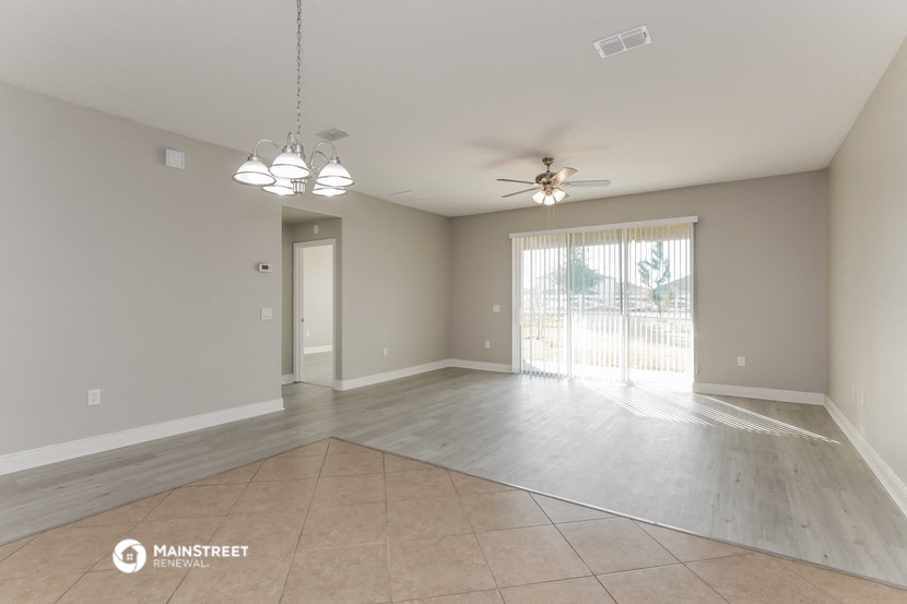 the spacious living room and dining room with a ceiling fan