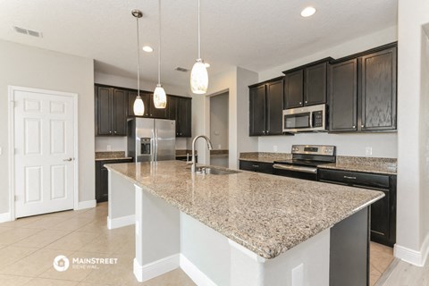 a kitchen with granite counter tops and black cabinets