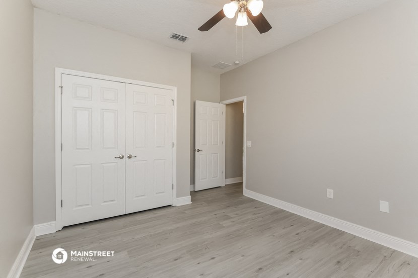 the living room of a new home with white doors and a ceiling fan