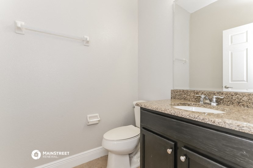 a bathroom with a toilet and a sink and a mirror