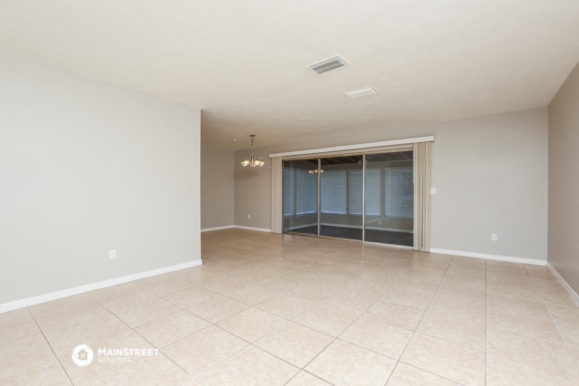 an empty living room with a large tile floor and a glass closet